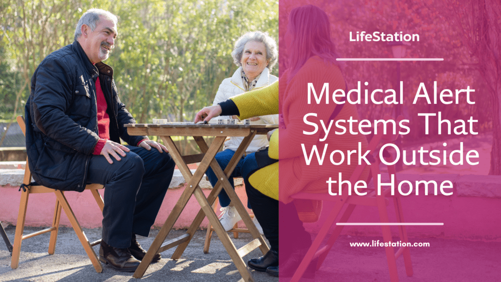 Two elderly individuals sitting outdoors playing a board game, with a banner promoting mobile medical alert systems that work outside the home, ensuring safety during outdoor activities.